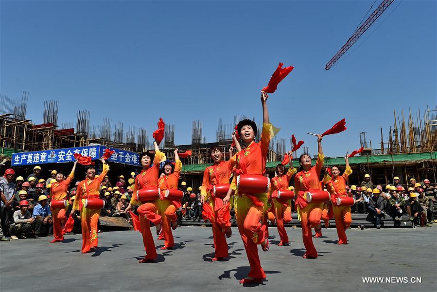 Migrant workers watch a folk show at a construction site in Yuncheng city, north China&apos;s Shanxi Province, April 28, 2017. Over 600 migrant workers from southwest Sichuan province gathered together to celebrate the upcoming Labor Day holiday.(Xinhua/Cao Yang) 