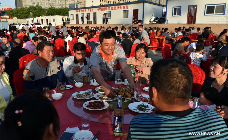 Migrant workers have a meal at a construction site in Yuncheng city, north China&apos;s Shanxi Province, April 28, 2017. Over 600 migrant workers from southwest Sichuan province gathered together to celebrate the upcoming Labor Day holiday.(Xinhua/Cao Yang) 