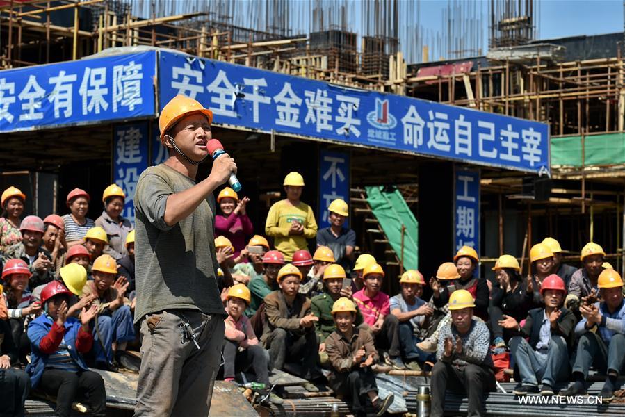 A migrant worker sings at a construction site in Yuncheng city, north China&apos;s Shanxi Province, April 28, 2017. Over 600 migrant workers from southwest Sichuan province gathered together to celebrate the upcoming Labor Day holiday.(Xinhua/Cao Yang) 