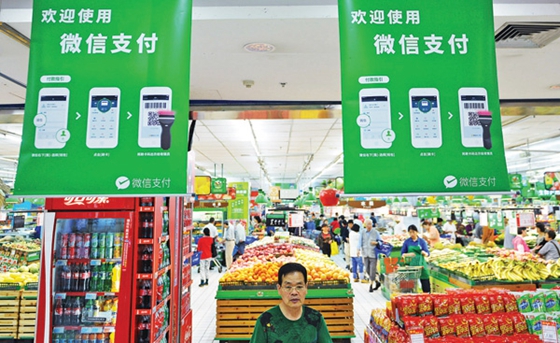 WeChat Pay advertisements hang from the ceiling at a supermarket in East China's Hangzhou city. [Photo/China Daily]