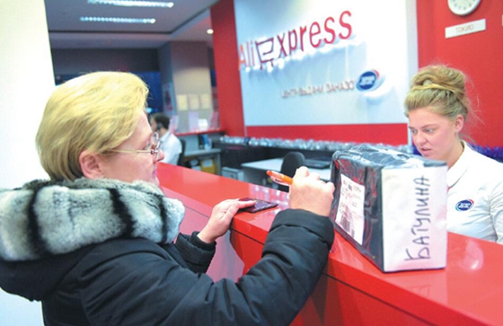 A Russian consumer shows her passport to identify herself at a goods collection center of AliExpress in Moscow. [Photo/Xinhua]
