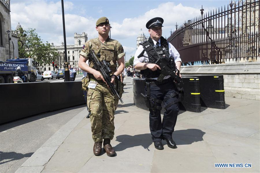 An armed soldier and an armed police officer patrol outside the Houses of Parliament in London, Britain, on May 24, 2017. British Prime Minister Theresa May announced Tuesday night that the country&apos;s terror threat level has been raised from &apos;severe&apos; to &apos;critical&apos;, its highest level. (Xinhua/Ray Tang) 