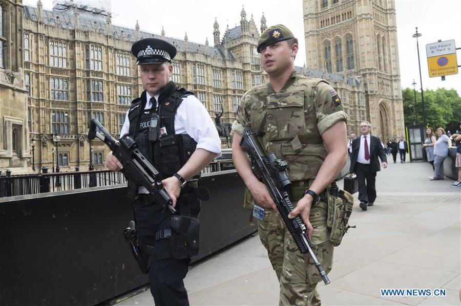 An armed soldier and an armed police officer patrol outside the Houses of Parliament in London, Britain, on May 24, 2017. British Prime Minister Theresa May announced Tuesday night that the country&apos;s terror threat level has been raised from &apos;severe&apos; to &apos;critical&apos;, its highest level. (Xinhua/Ray Tang) 