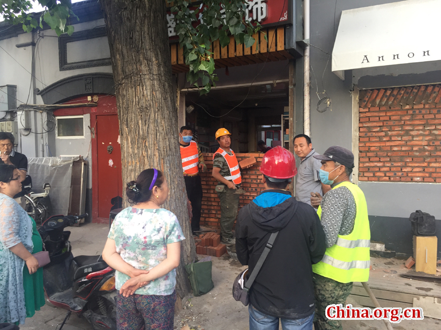 Locals gather round to watch the changing landscape of South Jianzi Alley, Beijing, on May 23, 2017. [Photo by Christopher Georgiou / China.org.cn] 
