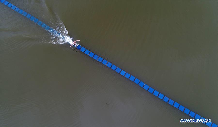 Shi Liliang, a monk from the Quanzhou Shaolin Temple, performs a Chinese martial art stunt by running on thin plywood in water for about 135 meters in Quanzhou City, southeast China's Fujian Province, June 3, 2017. (Xinhua/Zhang Jiuqiang)