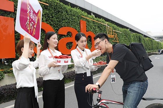 Working staff at Alibaba's Xixi garden in Huaian, Jiangsu province, feed a colleague with crayfish, a popular seasonal dish during summer in China, after the Xuyi government signed a cooperation agreement with Tmall to seek a wider online sales channel for the product. [Photo/China Daily] 