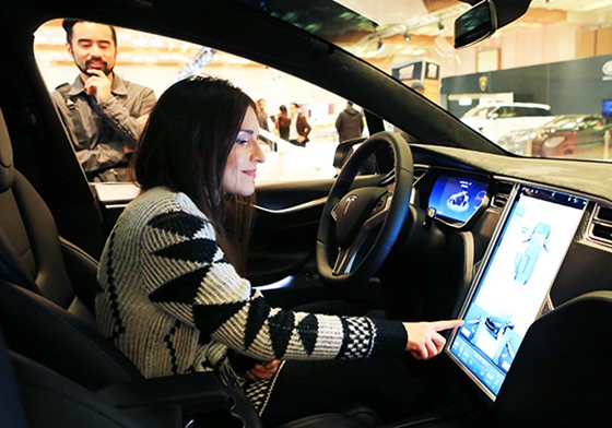  A woman experiences the touch screen of a Tesla car during an auto expo in Toronto, Canada. [Photo/Xinhua]