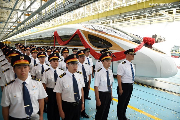 Staff members stand next to the CR400BF model of China's new electric multiple unit (EMU) train 'Fuxing' in Beijing, capital of China, June 25, 2017. China holds complete intellectual property rights of 'Fuxing' high speed trains. Two new 'Fuxing' trains will debut on Beijing-Shanghai high speed railway line on June 26, 2017 in Beijing and Shanghai at the same time. [Photo/Xinhua]