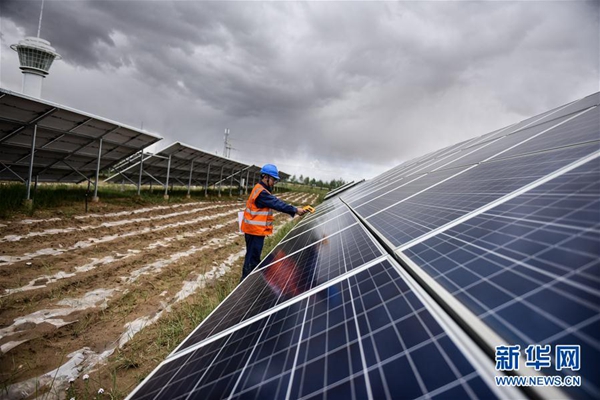 A staff member checks solar photovoltaic panels at a photovoltaic industrial park in Hainan Tibetan Autonomous Prefecture, northwestern China's Qinghai Province, June 21, 2017. From June 17 to midnight of June 23, the power supply for the entire Qinghai province relied only on clean energy from wind, solar and hydro power. [Photo/Xinhua]