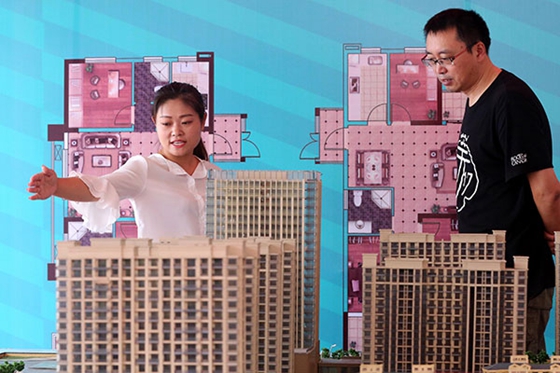 Denizens of Huai'an, Jiangsu province, look at a property model at an autumn expo in Sept 2016. [Provided to China Daily] 