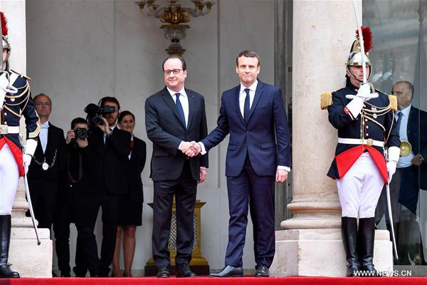 French president Emmanuel Macron (Front R) shakes hands with the outgoing French president Francois Hollande (Front L) during an inauguration ceremony at the Elysee Palace in Paris, France, on May 14, 2017. [Photo/Xinhua] 