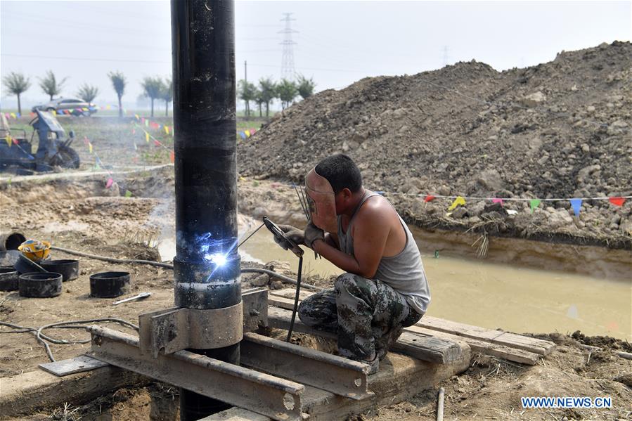An expert welds a pipe at Dawang Township of Anxin County, north China&apos;s Hebei Province, July 1, 2017. The geological survey has started in Xiongan New Area, a new economic zone near Beijing. (Xinhua/Jin Liangkuai)