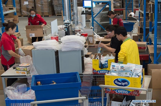 Staff members pack the express packages at JD's warehouse in the pilot free trade zone in north China's Tianjin Municipality, April 28, 2017. [Photo/Xinhua]