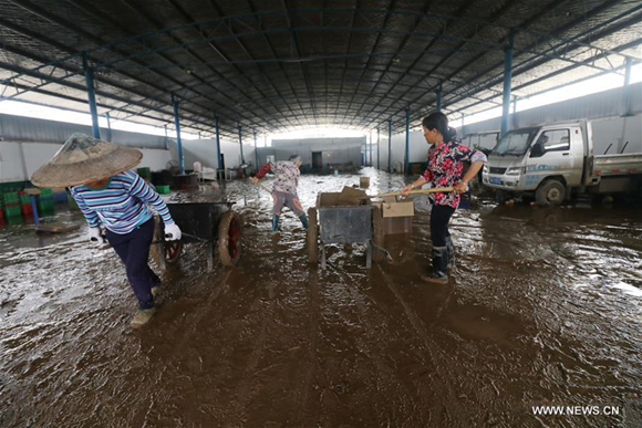 Staff members clear away mud after a flood at a vegetable base in Lianyuan City, central China's Hunan Province, July 3, 2017. Works of epidemic prevention and mud-cleaning are underway as floods subsided in central China's Hunan Province and south China's Guangxi Zhuang Autonomous Region. (Xinhua/Zhang Yang) 