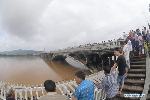 Citizens watch the flood on a bridge in Changsha, capital of central China's Hunan Province, July 2, 2017. Days of torrential rain in Hunan Province raised the water level of the Xiangjiang River, a major tributary of Yangtze River, to exceed its record flood level Sunday morning. (Xinhua/Long Hongtao) 