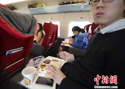 Passengers eat food on the train. China's high-speed railway now offers food which can be booked in advance online. [Photo/Chinanews.com]