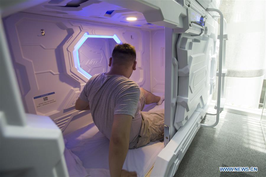 A man experiences a shared compartment in Shanghai, east China, July 14, 2017. The shared compartment service appeared in some office buildings in Shanghai recently. People can enjoy a rest in the compartment by scanning the QR codes for payment. Disposable bedding is provided and the compartment will be disinfected automatically by ultraviolet light after use. [Photo/Xinhua]