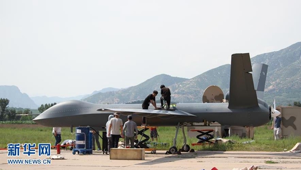 Staff workers prepare for the trial flight of China's unmanned aerial vehicle CH-5, or 'Rainbow 5'. [Photo/Xinhua]