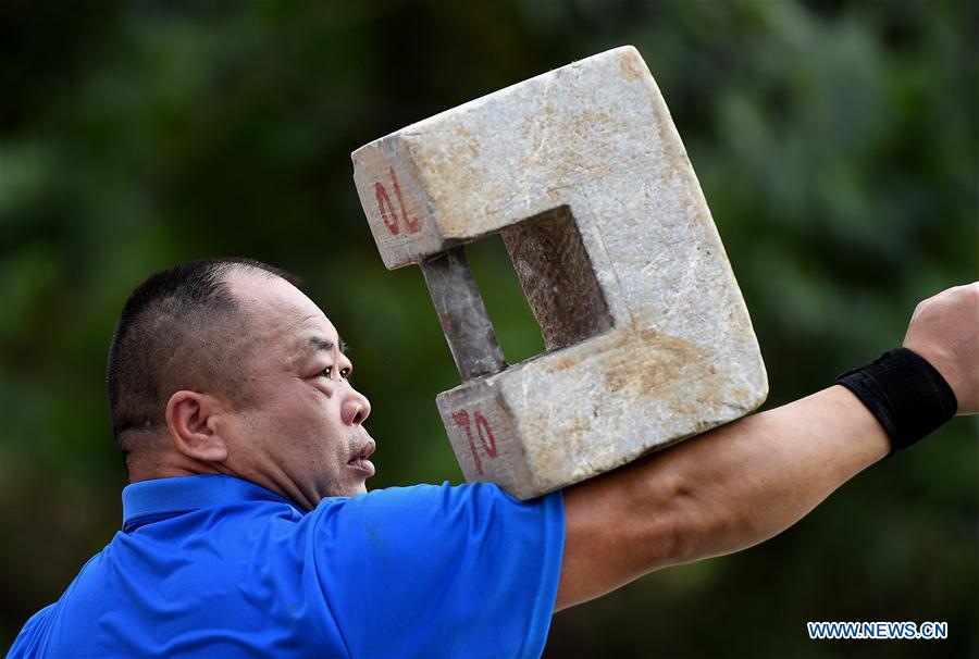 A contestant performs in the Stone Lock Kungfu category during a martial arts competition held in Shaolin Temple, central China&apos;s Henan province, July 30, 2017. The competition features four traditional events of Iron Palm Kungfu, Stone Lock Kungfu, Two-Finger Zen and Flying Knife Kungfu. (Xinhua/Li An)