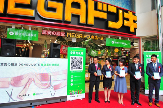 A ceremony involving digital ribbon cutting marks the opening of the 100th retailer in Tokyo where WeChat Pay will be accepted for shopping payments. [Photo/China Daily]