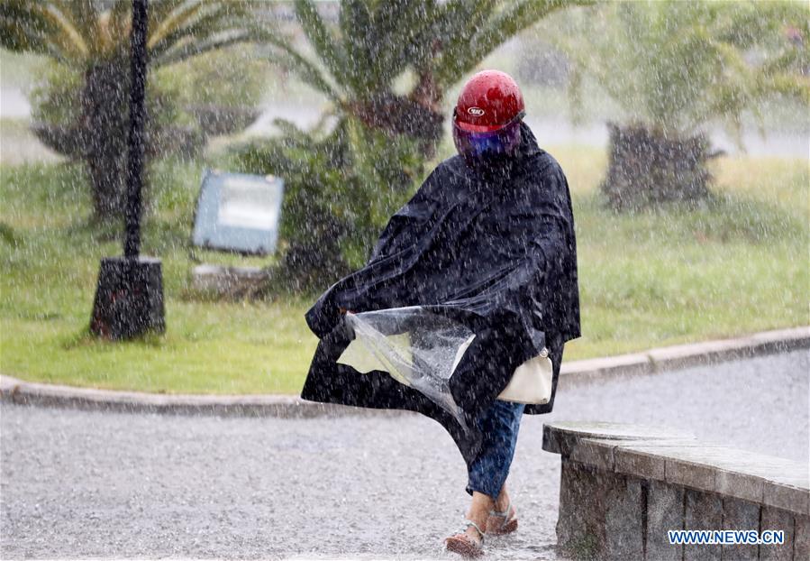 A pedestrian braves heavy rain in Fuqing, Fujian province, on July 31, 2017. Tropical Storm Haitang made landfall in the city on Monday morning in the wake of Typhoon Nesat, which roared into the city on Sunday. The government has warned people about the potential of floods and landslides.[Photo/Xinhua]