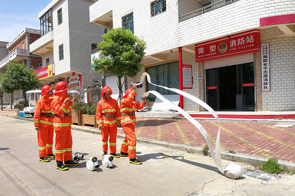 The women firefighters practice throwing fire hoses in Shantou village, Dadeng Island in East China's Fujian province, on July 24, 2017. [Photo provided to chinadaily.com.cn] 