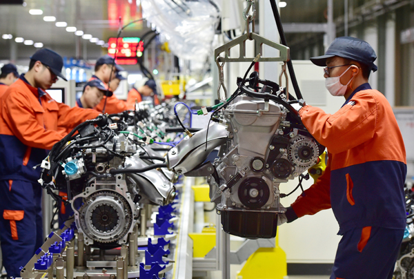Technical workers assemble engines at a plant in Yiwu, Zhejiang Province. [Photo provided for China Daily]