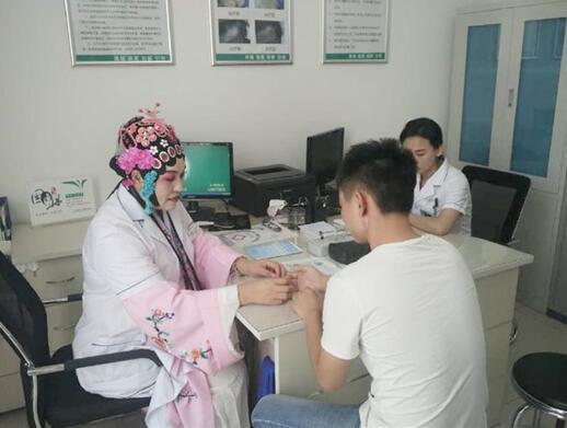 Chinese doctor Bai Shufang, dressed up as a Peking Opera artist, is pictured as she examines a patient at a hospital in Beijing on August 15, 2017.