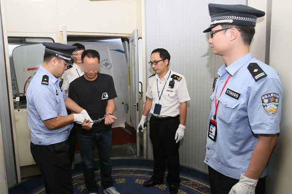 Ji Wenhong is detained on suspicion of smuggling luxuries at Xiamen Gaoqi International Airport in Fujian province on Wednesday. Ji was returned to China after Interpol captured him in Indonesia. [Photo/Xinhua]