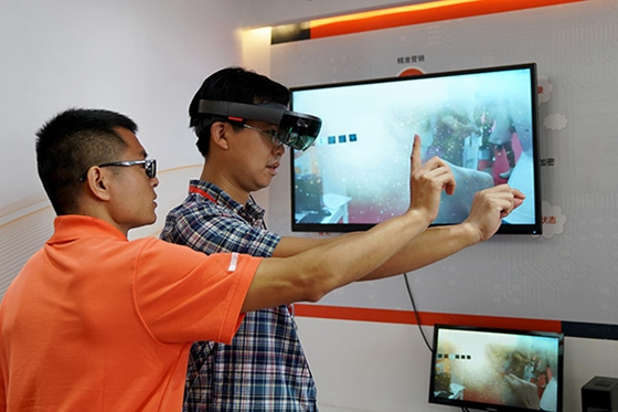 Participants try mixed reality technology applications at the 25th China International Financial Exhibition held from July 27 to 30 in Beijing. [Photo/Xinhua]