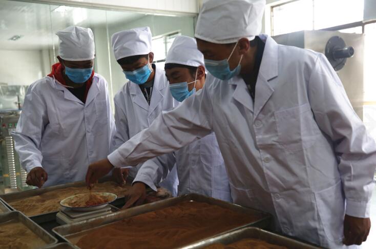 Students of Tibetan medicine major in the Second Middle Vocational School of Lhasa weigh the Tibetan medicine powder to make refreshing sachets in a model training laboratory of the school. [Photo / China.org.cn]