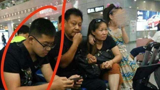 Screen shot of Duan (1st left) sitting with his family at the Nanjing South Railway Station [File photo: Weibo.com]