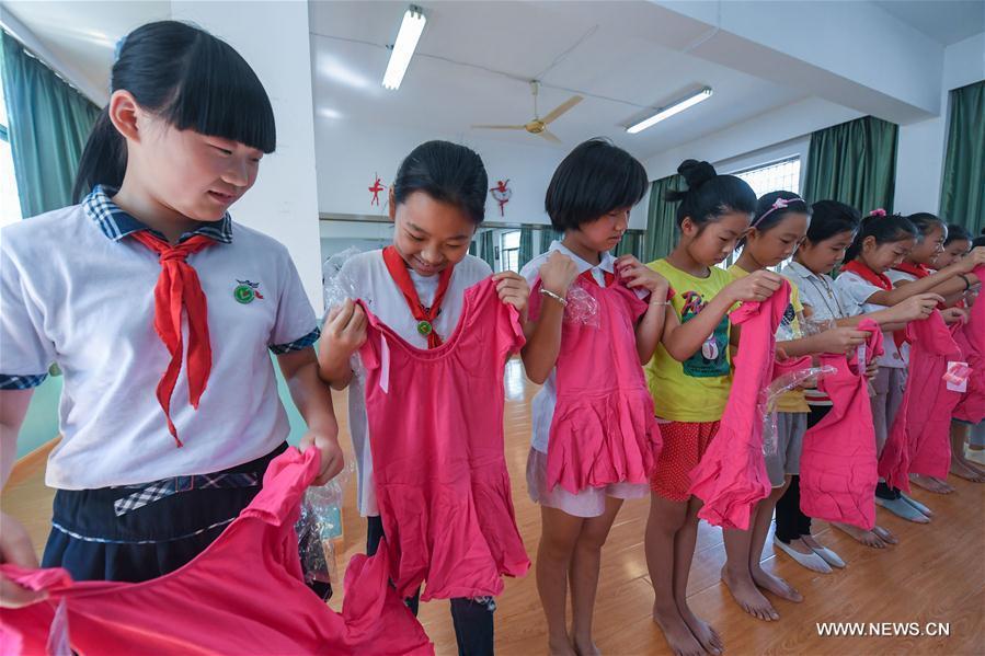 Dance troupe members try new cloths in the Red Army Primary School in Liangnong Town of Yuyao City, east China's Zhejiang Province, Sept. 1, 2017.