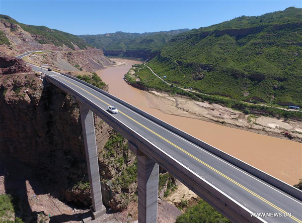 A car travels along the Yan'an section of the Yanhuang Highway in August. The highway, stretching 828.5 kilometers along the west bank of the Yellow River, opened on Aug 28 and is set to benefit more than 2 million residents.[Photo by Shao Rui/Xinhua] 