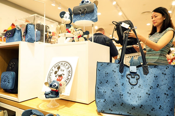 Visitors examine products at a Disney shop in Shanghai, which opened last week. [Photo/China News Service] 