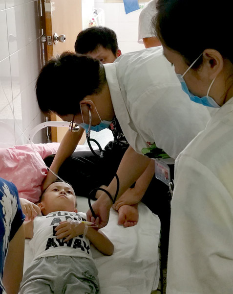 Medical personnel at Jiangxi Provincial Children's Hospital in Nanchang, Jiangxi province, treat a boy for food poisoning on Wednesday. [Photo/China Daily] 