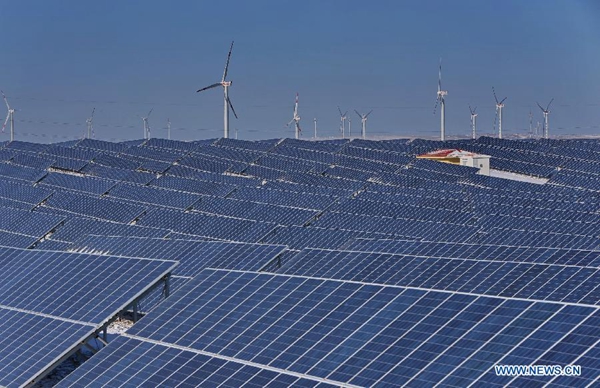 A photovoltaic power plant and a nearby wind power farm in Zhangjiakou, north China&apos;s Hebei Province, Jan. 19, 2015. The local government has combined air pollution control and energy structure change by using photovoltaic and wind power in recent years. [File photo/Xinhua]