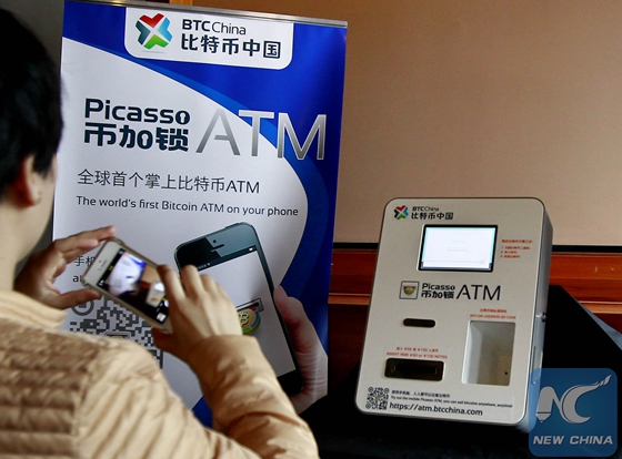 A citizen takes photos of a bitcoin ATM in east China's Shanghai, April 16, 2014. [Photo/Xinhua]