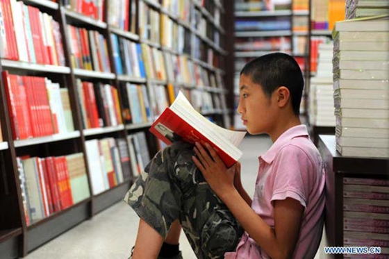 A boy reads a book at a Xinhua Bookstore in Changchun, capital of northeast China's Jilin province, Aug 13, 2012. [Photo/Xinhua]