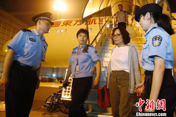 A female fugitive wanted for graft under an Interpol red notice steps down from a plane at an airport in Shanghai on Sept 19, 2017. [Photo/chinanews.com] 