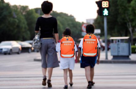 Children with orange schoolbags crossing the road. [Photo: adfc.org.cn]
