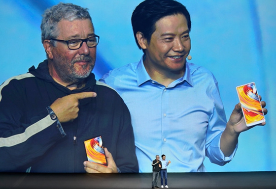 Lei Jun (right), chief executive officer of tech company Xiaomi, presents a full-screen smartphone with its French designer, Philippe Starck, at a new product launch event in Beijing on Sept 11. [Photo/China Daily]