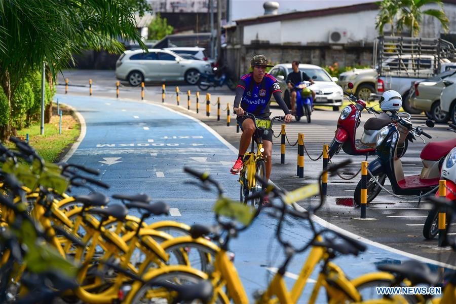 A man rides an ofo sharing-bike on a bike lane at a public park in Phuket, Thailand, Oct. 6, 2017. China's dock-less bike-sharing company ofo provide d more than 1,000 bikes in Phuket's key locations in late September and offered a 1-month free trial without deposit fee. Now the bike-sharing service has benefited local residents and tourists. Ofo's regular service fee will be charged at 5 Baht per 30 minutes usage, with a deposit fee of 99 Baht. [Photo/Xinhua]