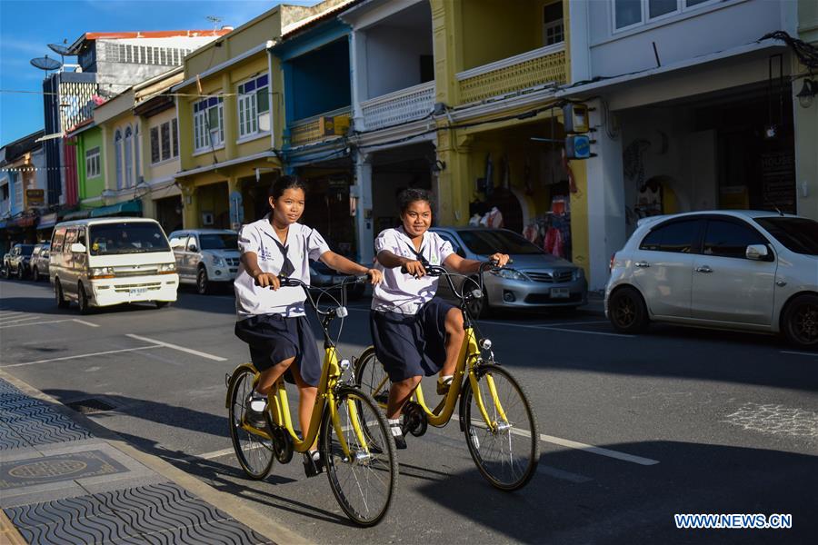 Local students ride ofo sharing-bikes at a commercial area in Phuket, Thailand, Oct. 5, 2017. China's dock-less bike-sharing company ofo provided more than 1,000 bikes in Phuket's key locations in late September and offered a 1-month free trial without deposit fee. Now the bike-sharing service has benefited local residents and tourists. Ofo's regular service fee will be charged at 5 Baht per 30 minutes usage, with a deposit fee of 99 Baht. [Photo/Xinhua]
