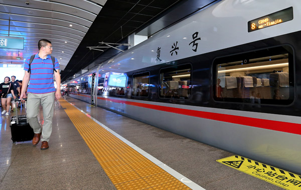 A new Fuxing bullet train running between Tianjin and Beijing, prepares to leave the capital.[Photo by Wang Zhuangfei/China Daily] 