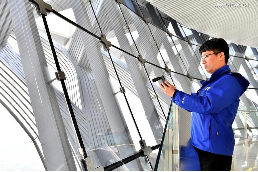 A journalist from Republic of Korea takes photos at the Olympic Tower in Beijing, capital of China, Oct. 12, 2017. The Press Center of the 19th National Congress of the Communist Party of China (CPC) organized a reporting tour along the Central Axis of Beijing on Thursday. Chinese and foreign reporters visited scenic attractions such as the Jingshan Park, Yongding Gate and the Olympic Tower. (Xinhua/Li Xin) 
