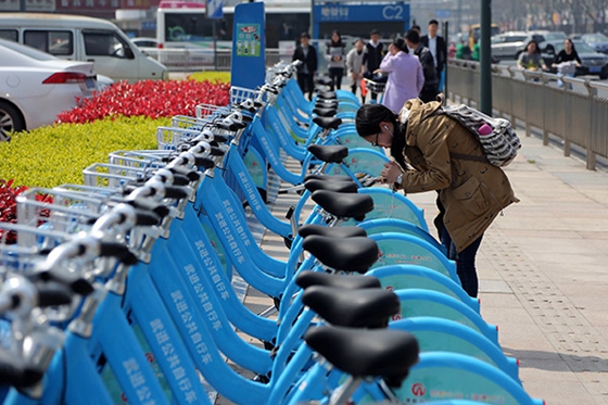 A denizen of Changzhou, Jiangsu province, rents a bike of Changzhou Youon by scanning a QR code. [Photo/China Daily]
