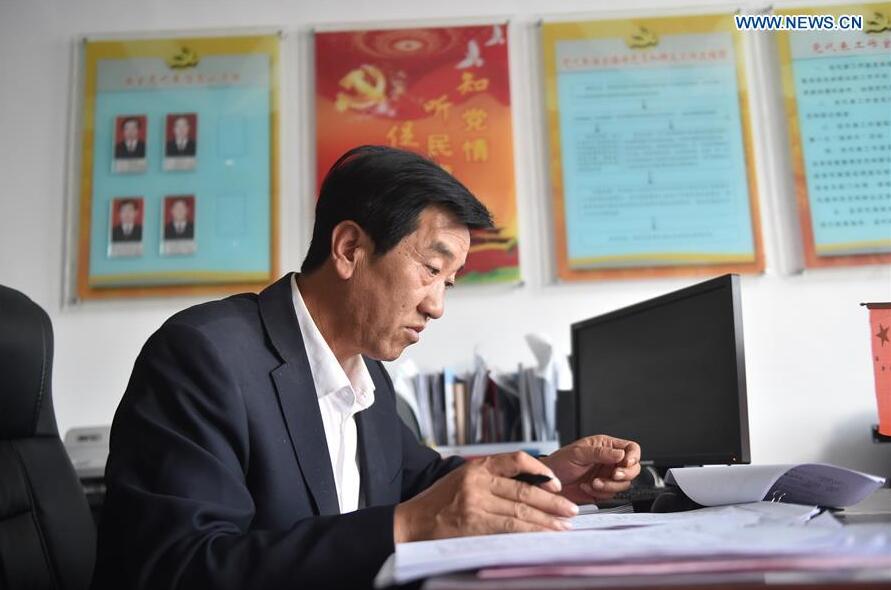 Zhu Yuguo, secretary of the Communist Party of China (CPC) branch of Zengjipan Village, works at his office in Yanchi County, northwest China's Ningxia Hui Autonomous Region, Sept. 20, 2017.