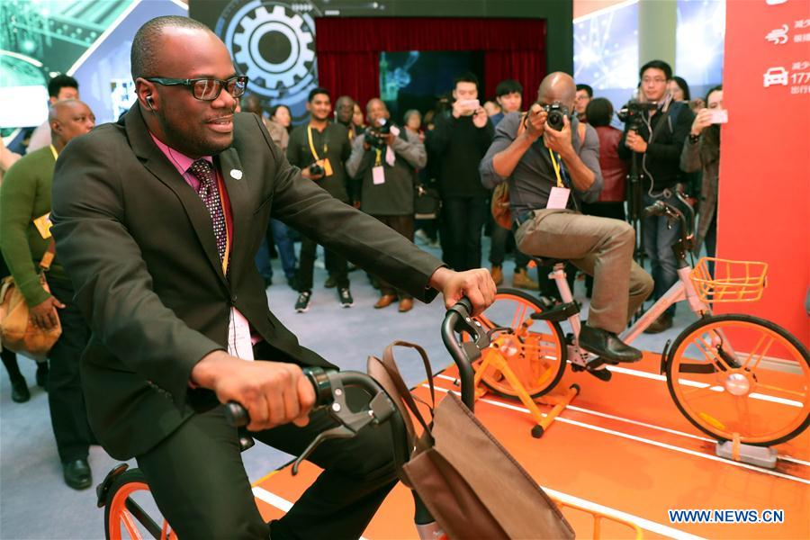 A journalist experiences a shared bike at Beijing Exhibition Center, in Beijing, capital of China, Oct. 16, 2017. Journalists from a number of developing countries visited an exhibition displaying China&apos;s outstanding achievements over the past five years here on Monday. (Xinhua/Zhang Yuwei)