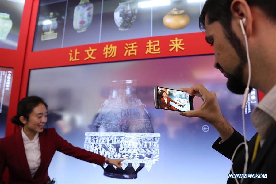 A journalist shoots video of a demonstration of Digital Palace Museum at Beijing Exhibition Center, in Beijing, capital of China, Oct. 16, 2017. Journalists from a number of developing countries visited an exhibition displaying China&apos;s outstanding achievements over the past five years here on Monday. (Xinhua/Zhang Yuwei) 